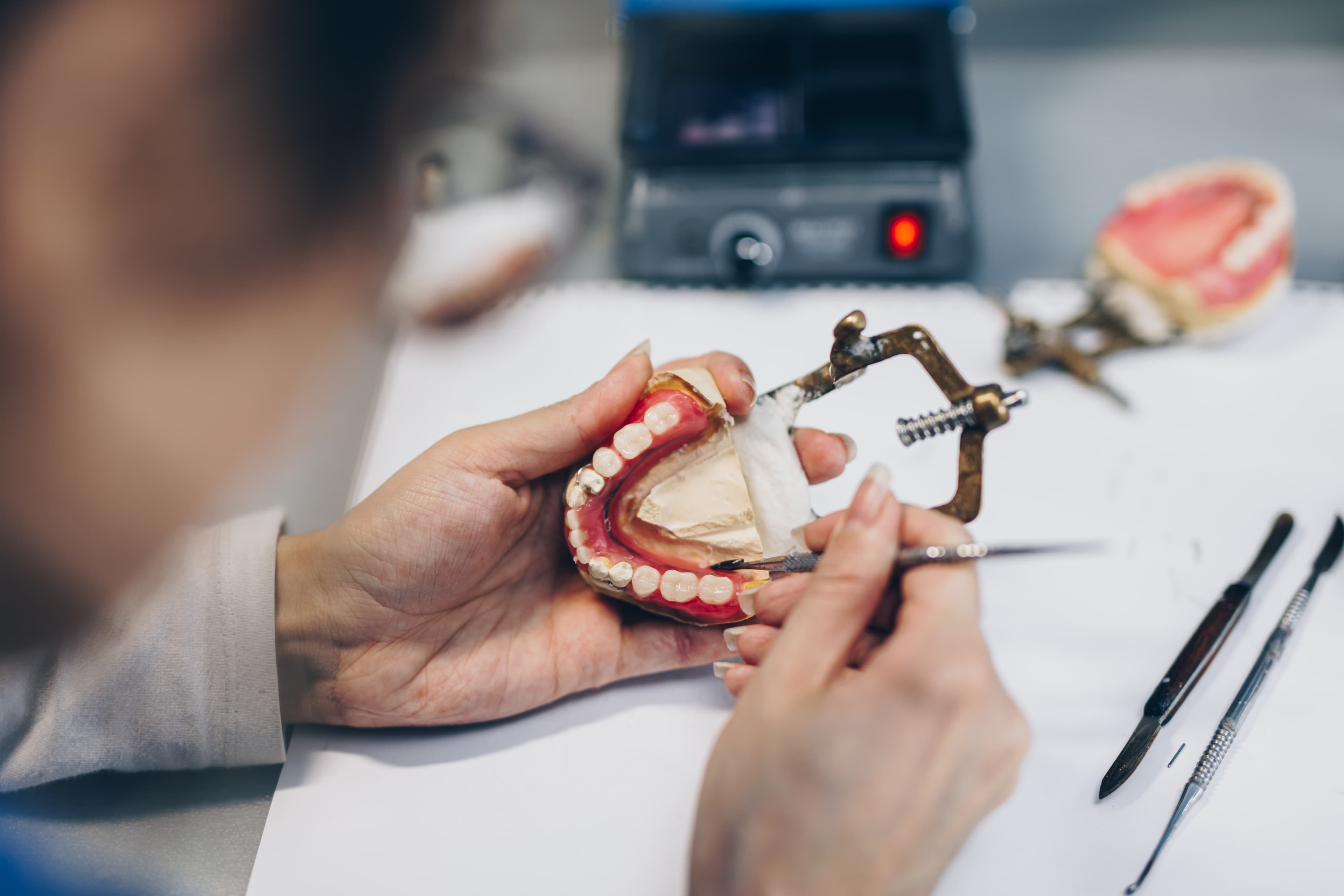 Zahntechniker bei der Präzisionsarbeit an einer Prothese